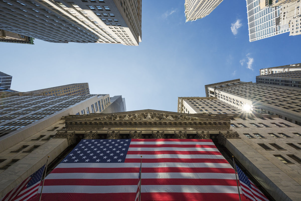 La Borsa di New York (NYSE) con la grande bandiera americana tra i grattacieli